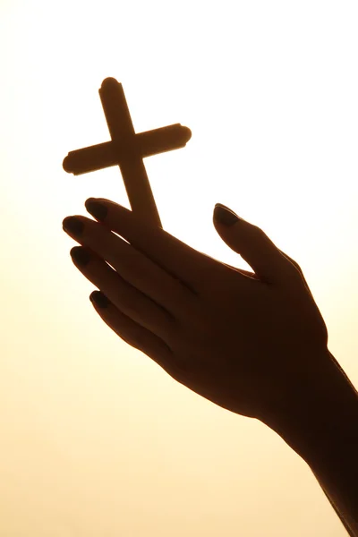 Mãos femininas com crucifixo, no fundo bege — Fotografia de Stock