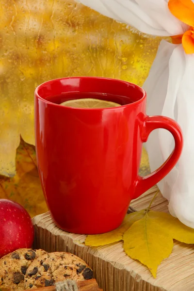 Cup of hot tea and autumn leaves, on rain background — Stock Photo, Image