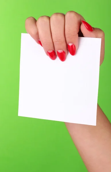 Mano della donna che tiene carta bianca su sfondo a colori — Foto Stock