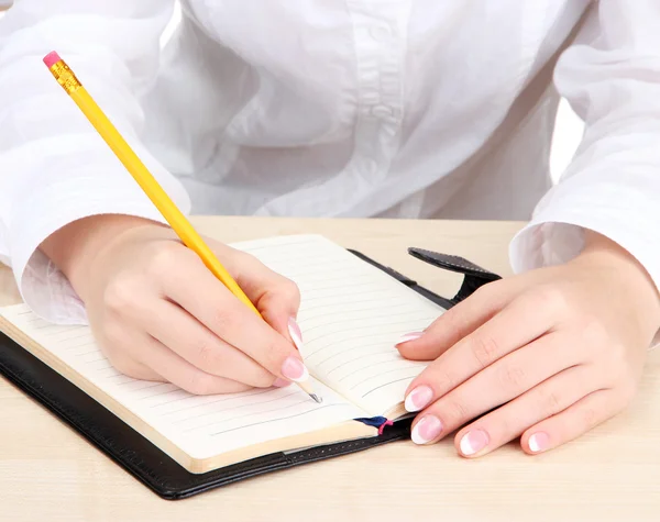 Fechar-se de mãos de mulher de negócios, escrevendo no papel — Fotografia de Stock