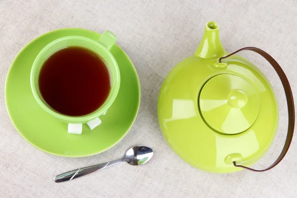 Draufsicht auf Tasse Tee und Teekanne auf Tischdecken — Stockfoto