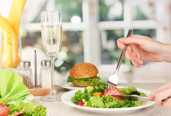 Kvinnlig hand med middag på ljus bakgrund — Stockfoto