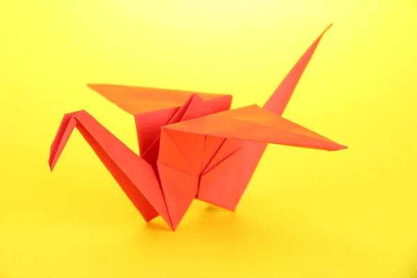 Origami jeřáb na žlutém podkladu — Stock fotografie