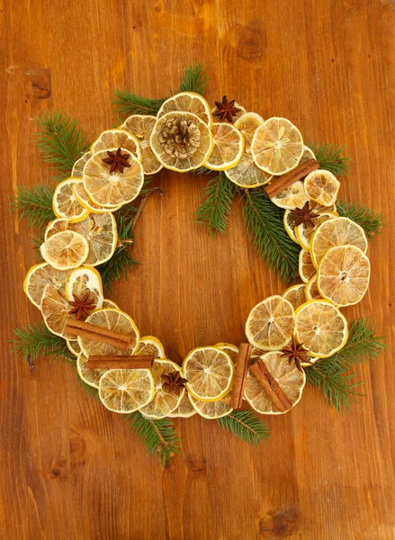 Corona de Navidad de limones secos con abeto sobre fondo de madera — Foto de Stock