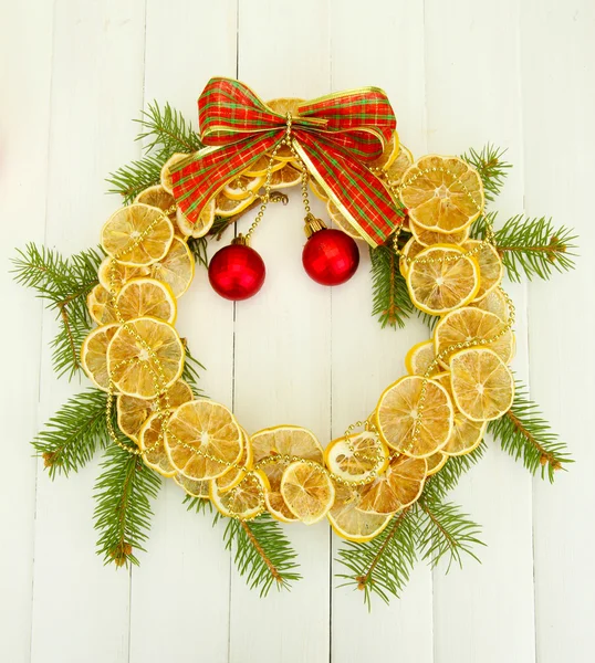 De kroon van Kerstmis van gedroogde citroenen met fir tree en ballen, op houten achtergrond — Stockfoto