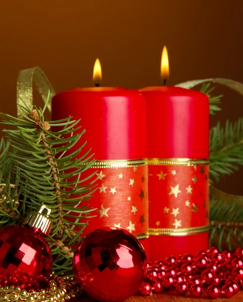 Dvě svíčky a vánoční ozdoby, na hnědé pozadí — Stock fotografie