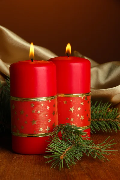 Due candele e decorazioni natalizie, su sfondo di stoffa dorata — Foto Stock