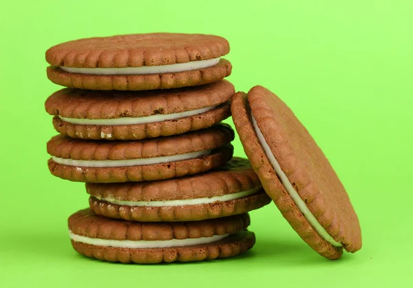 Chocolate cookies with creamy layer on green background — Stock Photo, Image