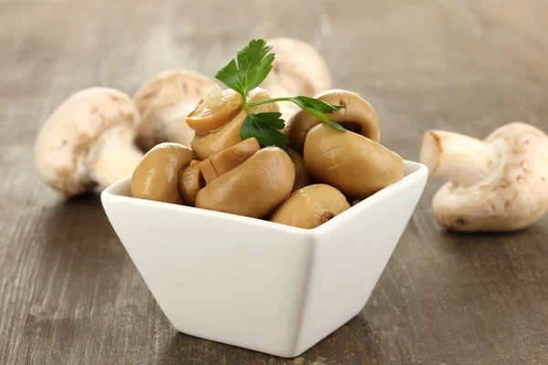 Delicious marinated mushrooms in bowl on wooden table close-up — Stock Photo, Image