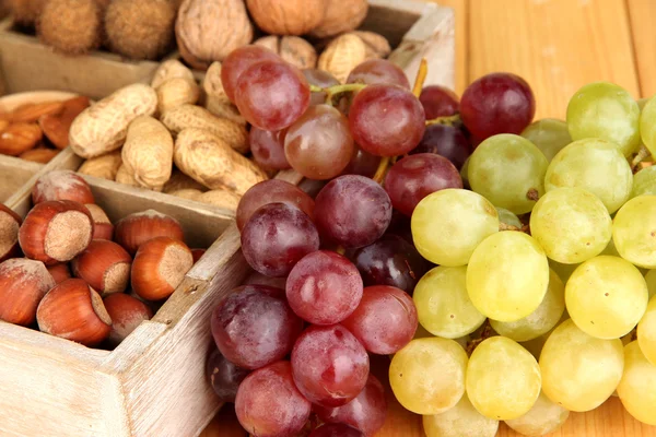 Grape with nuts on wooden table — Stockfoto