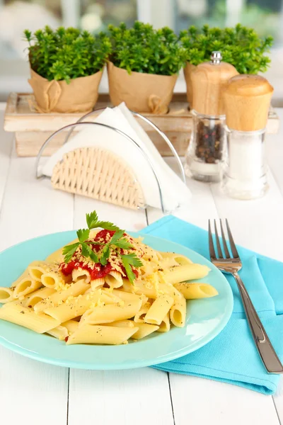 Rigatoni Nudelgericht mit Tomatensauce auf weißem Holztisch im Café — Stockfoto