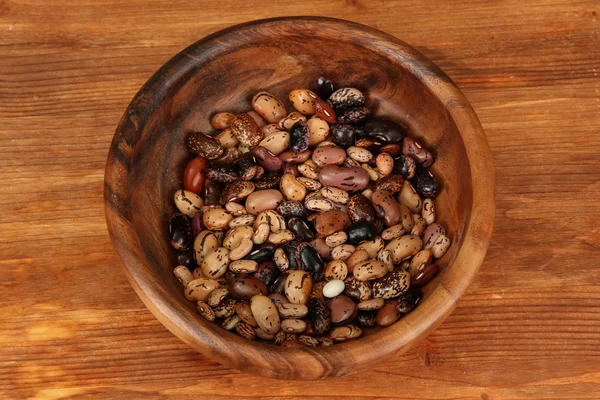 Cuenco de madera con frijoles sobre fondo de madera —  Fotos de Stock