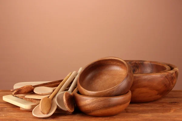 Drewniane naczynia na stole na brązowym tle — Zdjęcie stockowe
