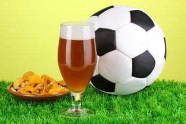 bardak bira ile çim yeşil zemin üzerine futbol topu
