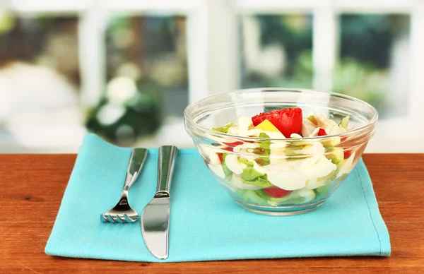 Squid salad with vegetables in a glass bowl on wooden table close-up — Stock Photo, Image
