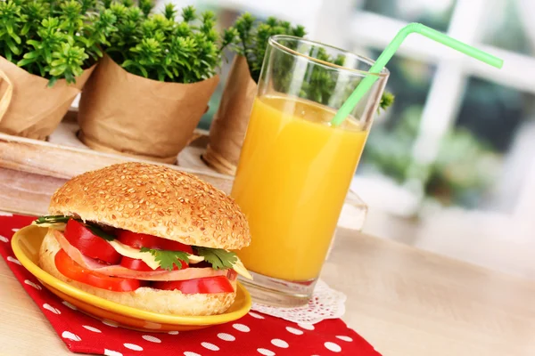 Appetizing sandwich on color plate on wooden table on window background — Stock Photo, Image