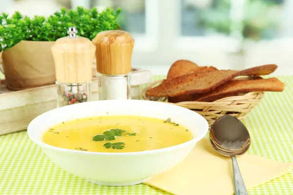 緑のテーブル クロスのウィンドウ背景のクローズ アップの上の白いプレートの香りスープ — ストック写真