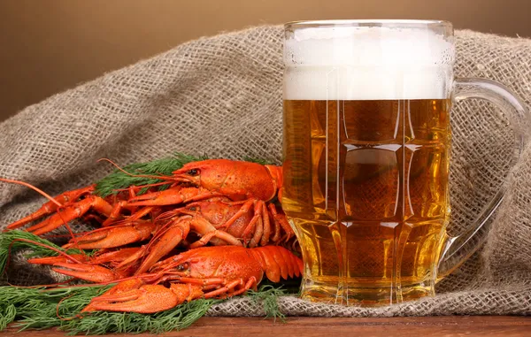 Tasty boiled crayfishes and beer on table on brown background — Stock Photo, Image
