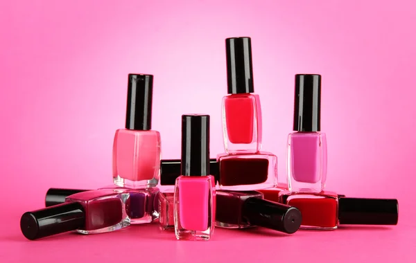 Grupp av ljusa nagellack, på rosa bakgrund — Stockfoto