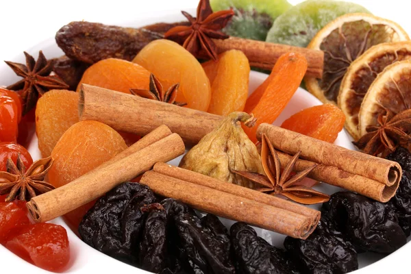 Dried fruits with cinnamon and anise stars on plate close-up — Stock Photo, Image