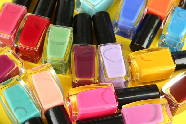 Grupo de esmaltes de uñas brillantes, sobre fondo amarillo —  Fotos de Stock