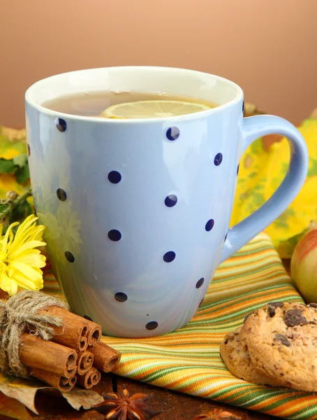 Taza de té caliente y hojas de otoño, sobre fondo marrón —  Fotos de Stock