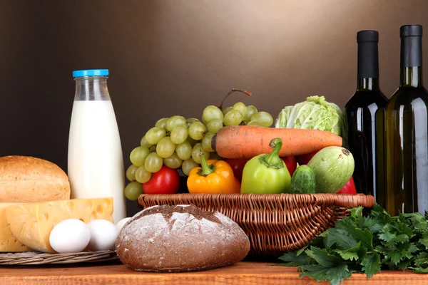 Composition avec légumes dans un panier en osier sur fond brun — Photo