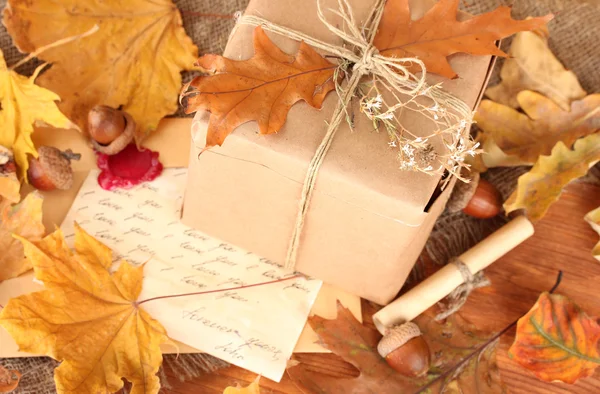 Podzimní pozadí: vintage dárek, dopis a listy — Stock fotografie