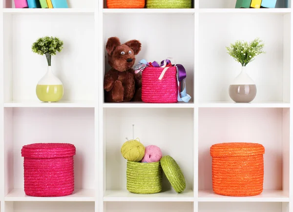 Caixas de vime de cor nas prateleiras do armário — Fotografia de Stock