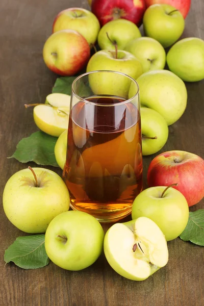 Användbara äppeljuice med äpplen runt på träbord — Stockfoto