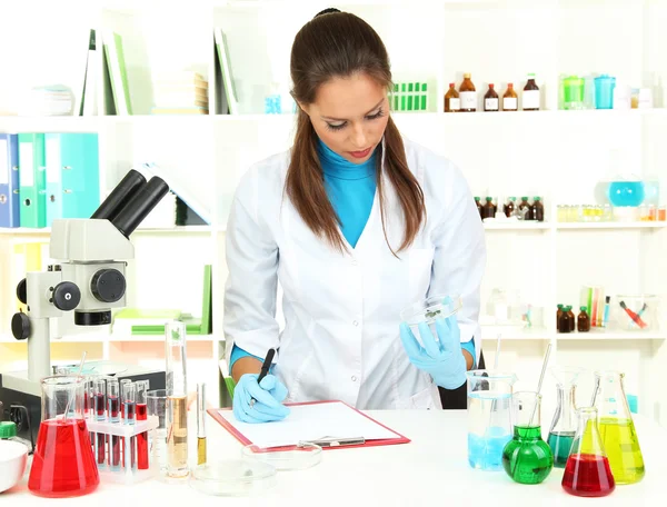 Young scientist looking into microscope in laboratory — Stock Photo, Image
