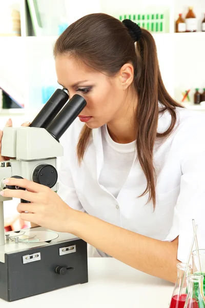 Νέος επιστήμονας εξετάζει μικροσκόπιο στο εργαστήριο — Φωτογραφία Αρχείου