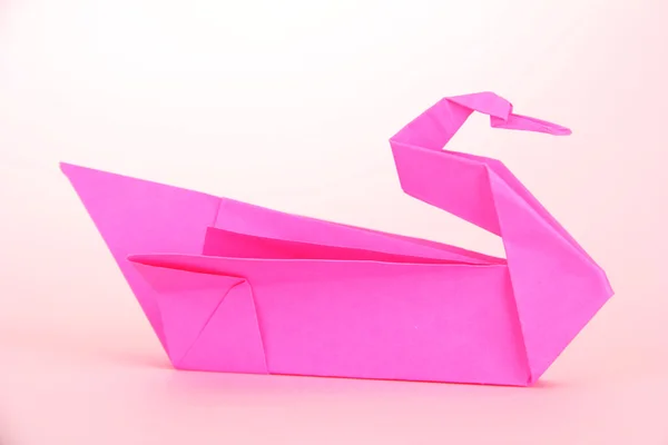Cisne de origami sobre fondo rosa — Foto de Stock