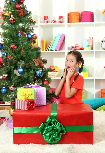 Niña con caja de regalo grande cerca del árbol de Navidad — Foto de Stock