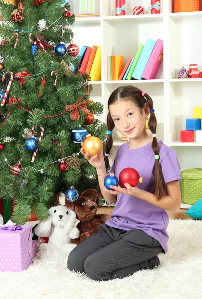 Κοριτσάκι στολίζει χριστουγεννιάτικο δέντρο — Φωτογραφία Αρχείου