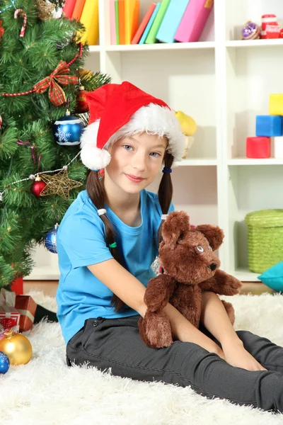 Niña sentada cerca del árbol de Navidad — Foto de Stock