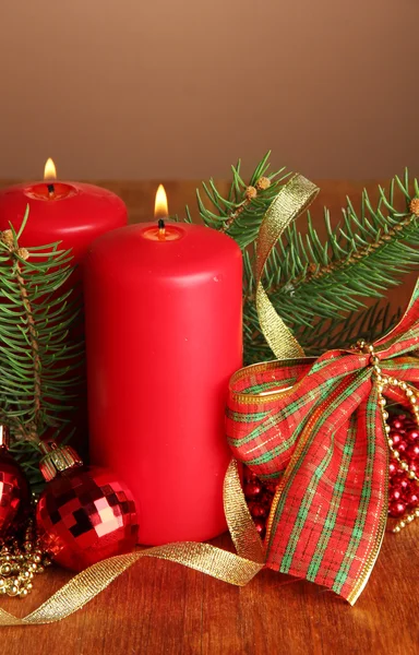 Twee kaarsen en kerstversiering, op bruine achtergrond — Stockfoto