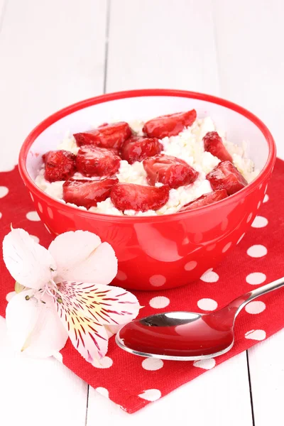 Queso de cabaña en tazón rojo con fresas en rodajas sobre mesa de madera blanca —  Fotos de Stock