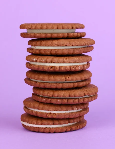 Biscoitos de chocolate com camada cremosa no fundo roxo — Fotografia de Stock