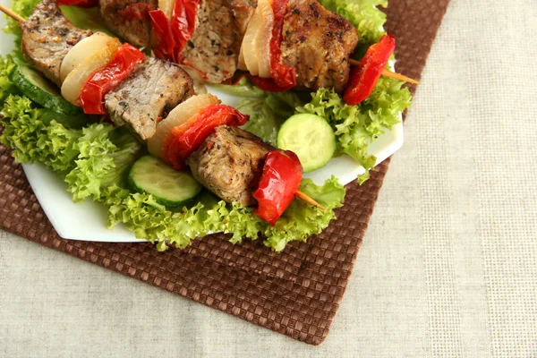 Gustose grigliate di carne e verdure su spiedino su piatto, su tavolo — Foto Stock