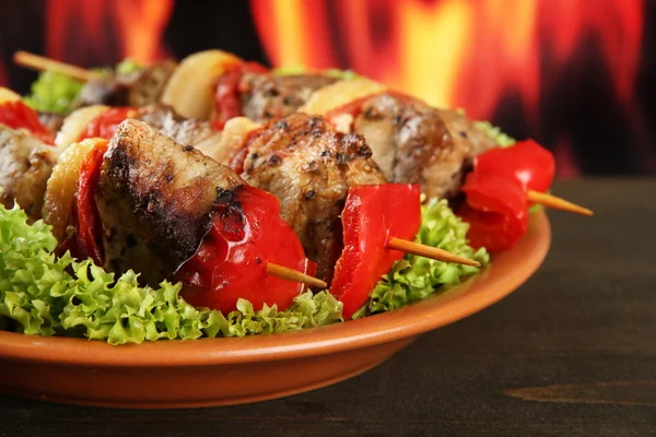 Смачне м'ясо та овочі на тарілці, на фоні вогню — стокове фото