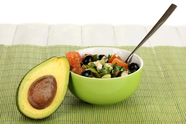 Tasty avocado salad in bowl on wooden table on white background — Stock Photo, Image