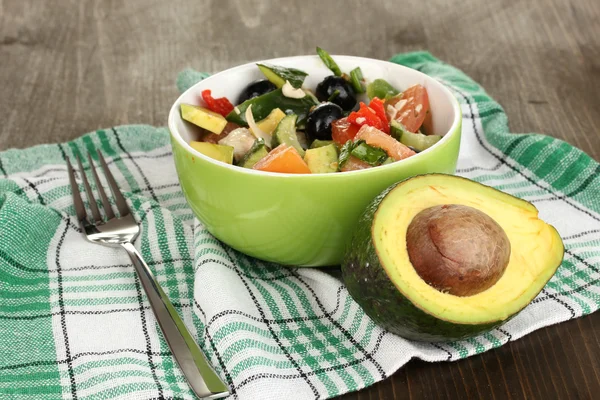 Välsmakande avokado sallad i skål på träbord närbild — Stockfoto