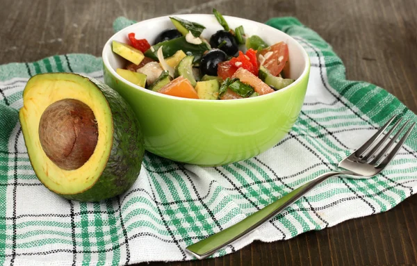 Välsmakande avokado sallad i skål på träbord närbild — Stockfoto