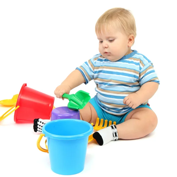 Küçük çocuk üzerinde beyaz izole plastik kürek ile oynama — Stok fotoğraf