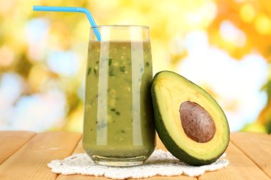 doğal zemin üzerine ahşap masa üstünde yarım avokado ve faydalı taze avokado