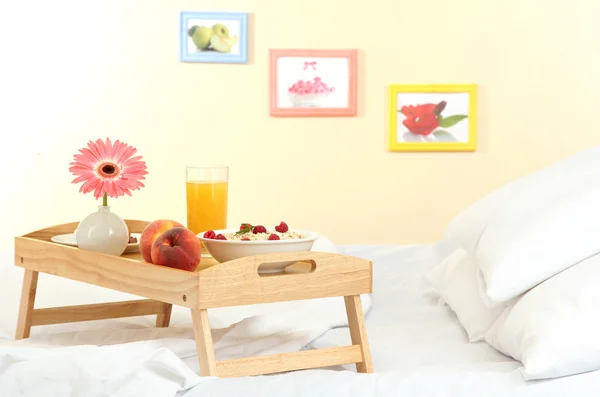 Wooden tray with light breakfast on bed — Stock Photo, Image