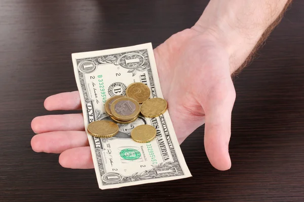 Contando dinero en mano sobre fondo de mesa de madera — Foto de Stock