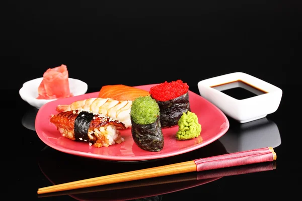 Delicious sushi served on red plate isolated on black — Stock Photo, Image