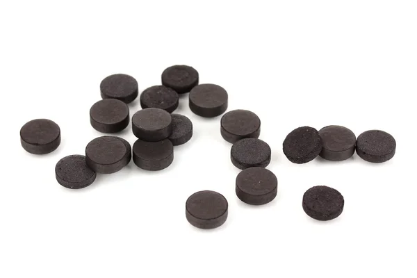 Carvão ativado em comprimidos isolados em branco — Fotografia de Stock